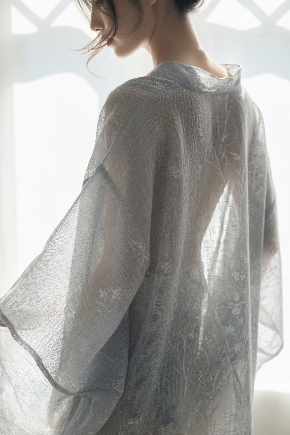 Backlit figure in a sheer summer kimono, the translucent gauze weave and the softly suggested form of the body reading against the light.